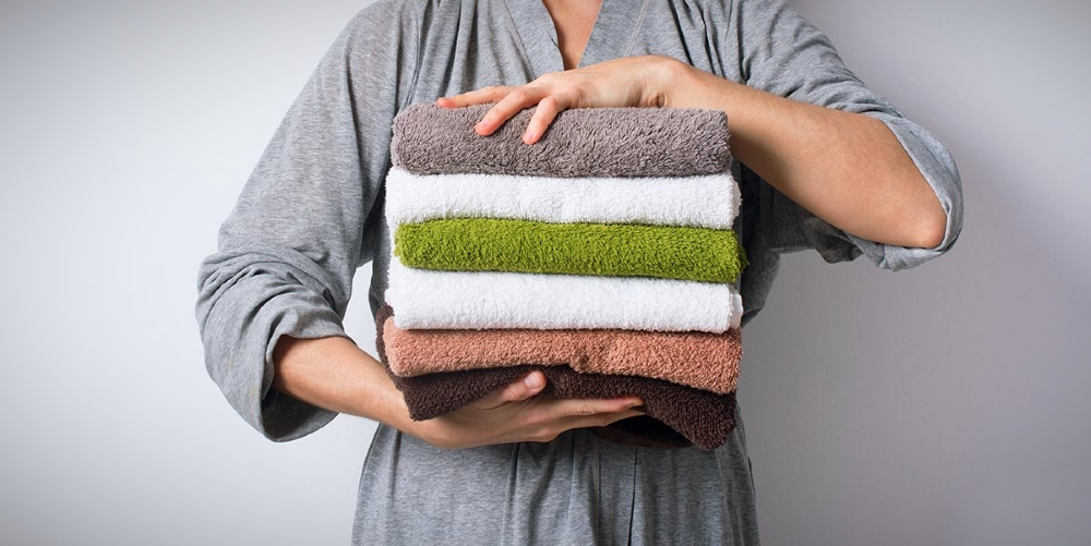 A imagem mostra um exemplo de uma mulher segurando algumas toalhas.